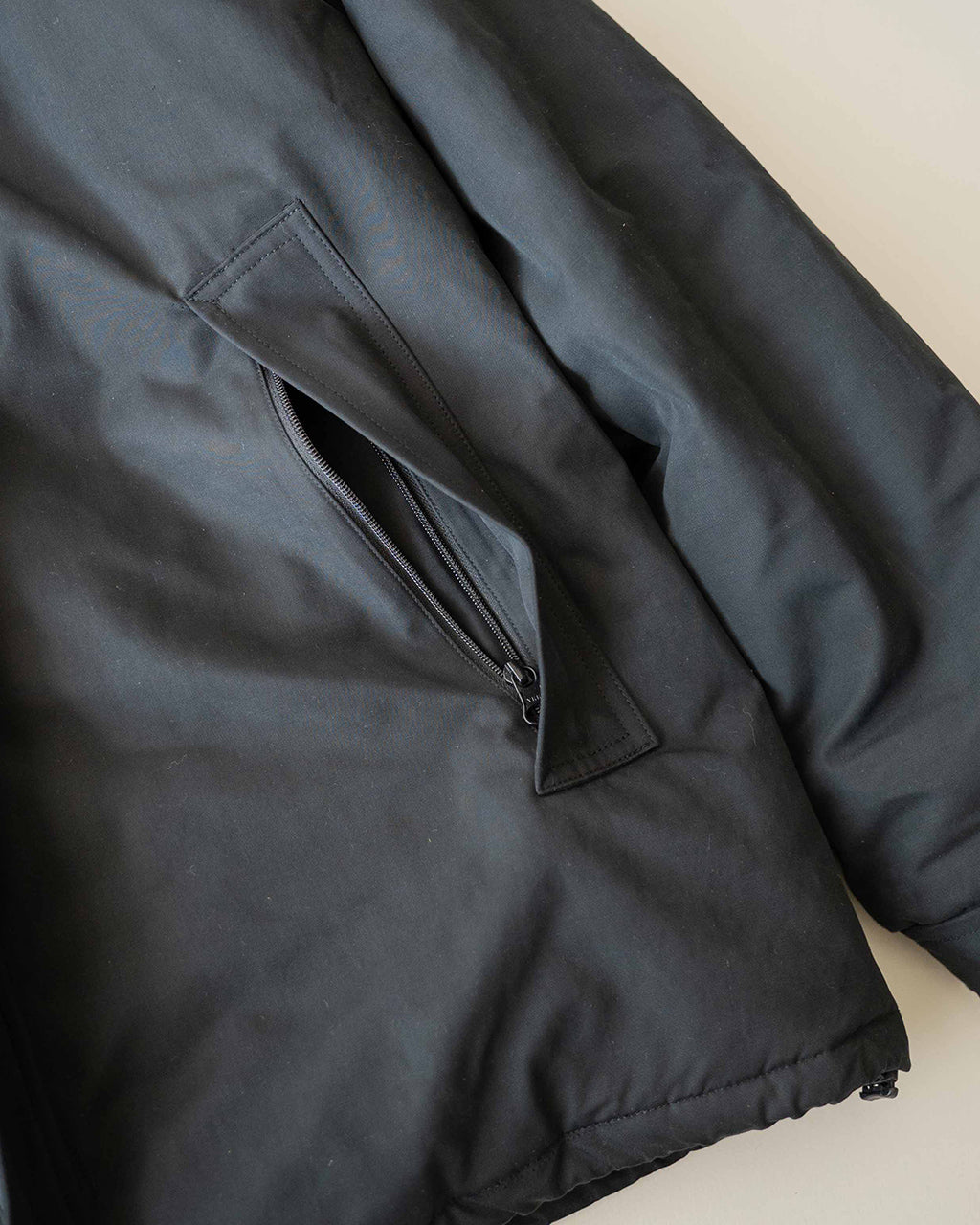ブラックのBaggies Jacket Ver.2の内ポケット周辺をアップで撮影。ジップとポケット口の細部が見え、撥水感のある生地の質感が伝わるディテール写真です。