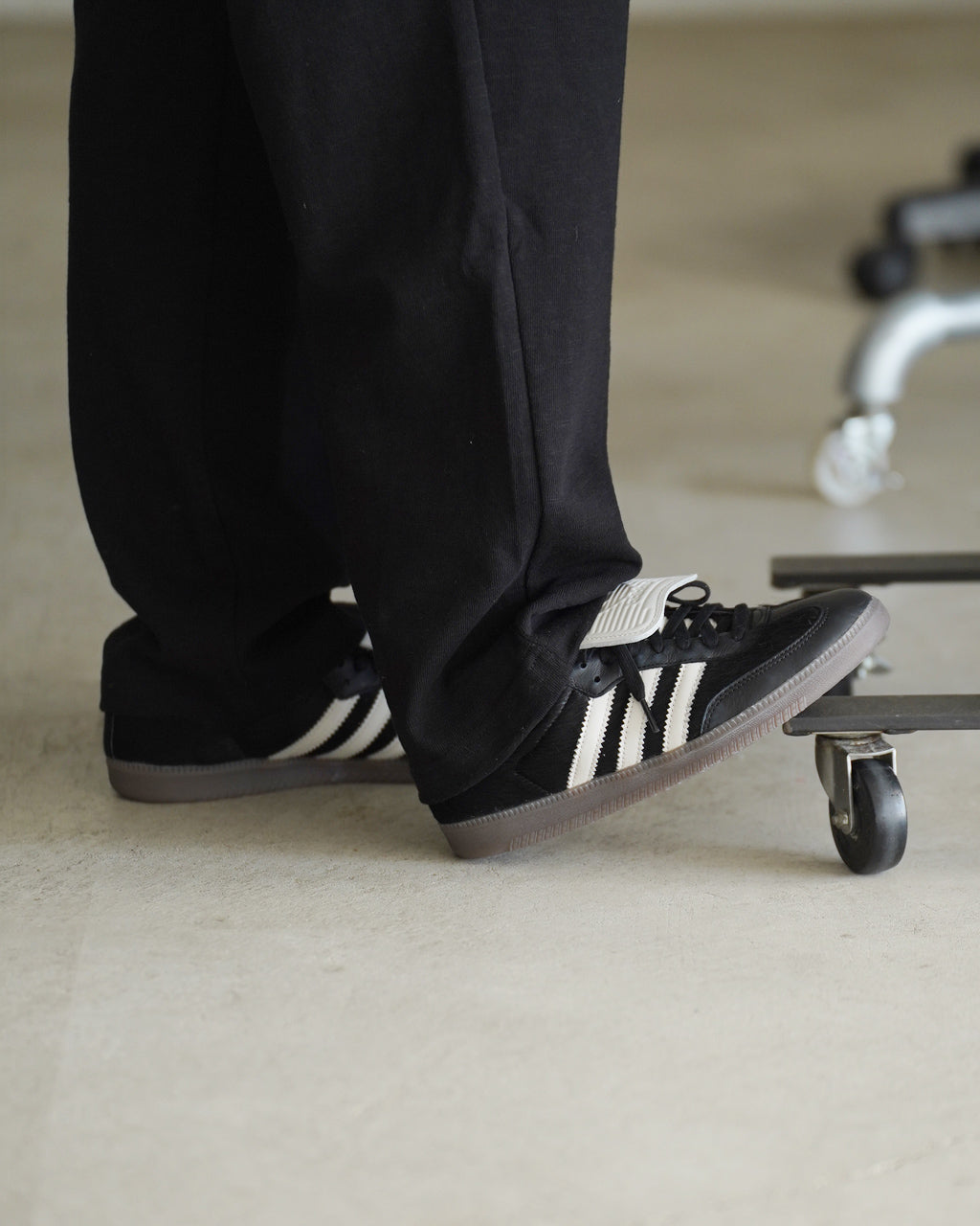 アディダスオリジナルスのスニーカー、黒と白の横ラインが目を引くスタイル。 treadが見えるアウトソールと低カットのデザインで、デニムにも合わせやすい佇まいです。