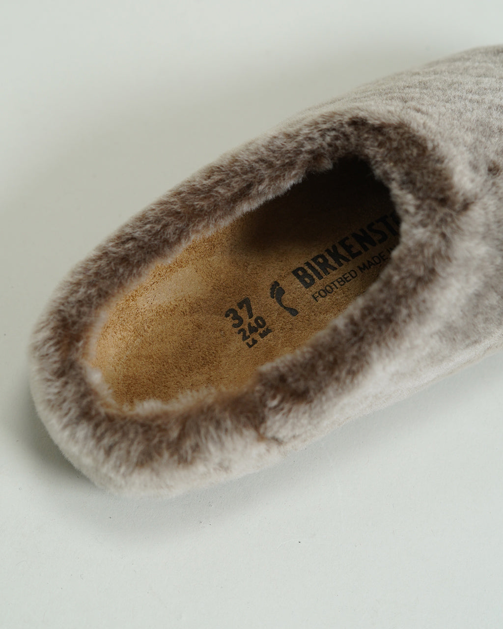 BIRKENSTOCK Amsterdam Wrapped Shearlingのソフトなファー素材アップ。淡いグレージュカラーの内張りと足当たりの良い内側を寄せた切替が見える横からのショット