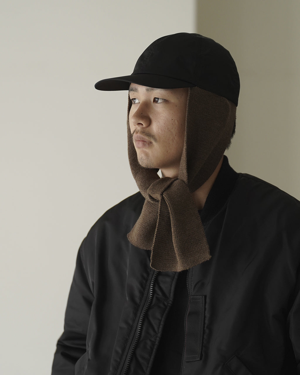 斜め正面からの着用写真。キャップとマフラーが顔まわりに沿い、首元の立ち上がりと垂れ感が分かる