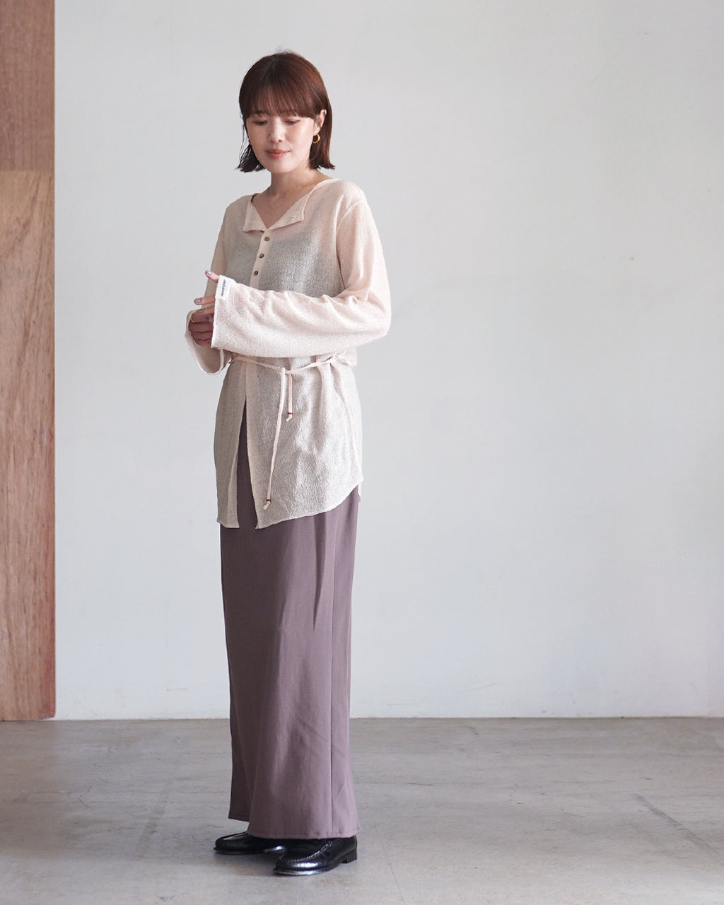 モーブカラーの Mood Pencil Skirt を着用したモデル。ウエストはゴム仕様で、前後にゆとりのあるペンシルシルエットと裾のドレープが特徴的なスタイルを示す全身写真。