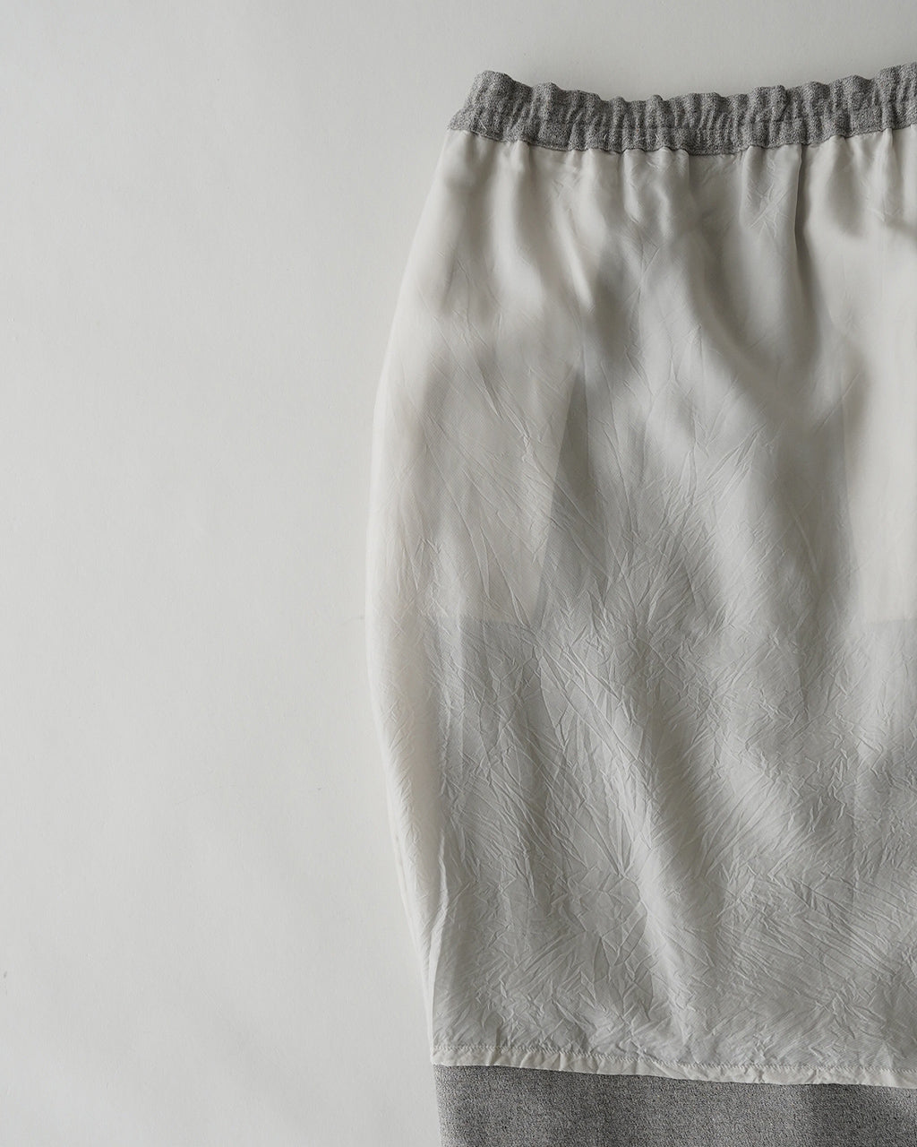 Melangeカラーの Mood Pencil Skirt。ウエスト裾に向かって緩やかなドレープが出るペンシルシルエットと、 GRAY系のアッパー布地の質感が特徴的な一枚です。