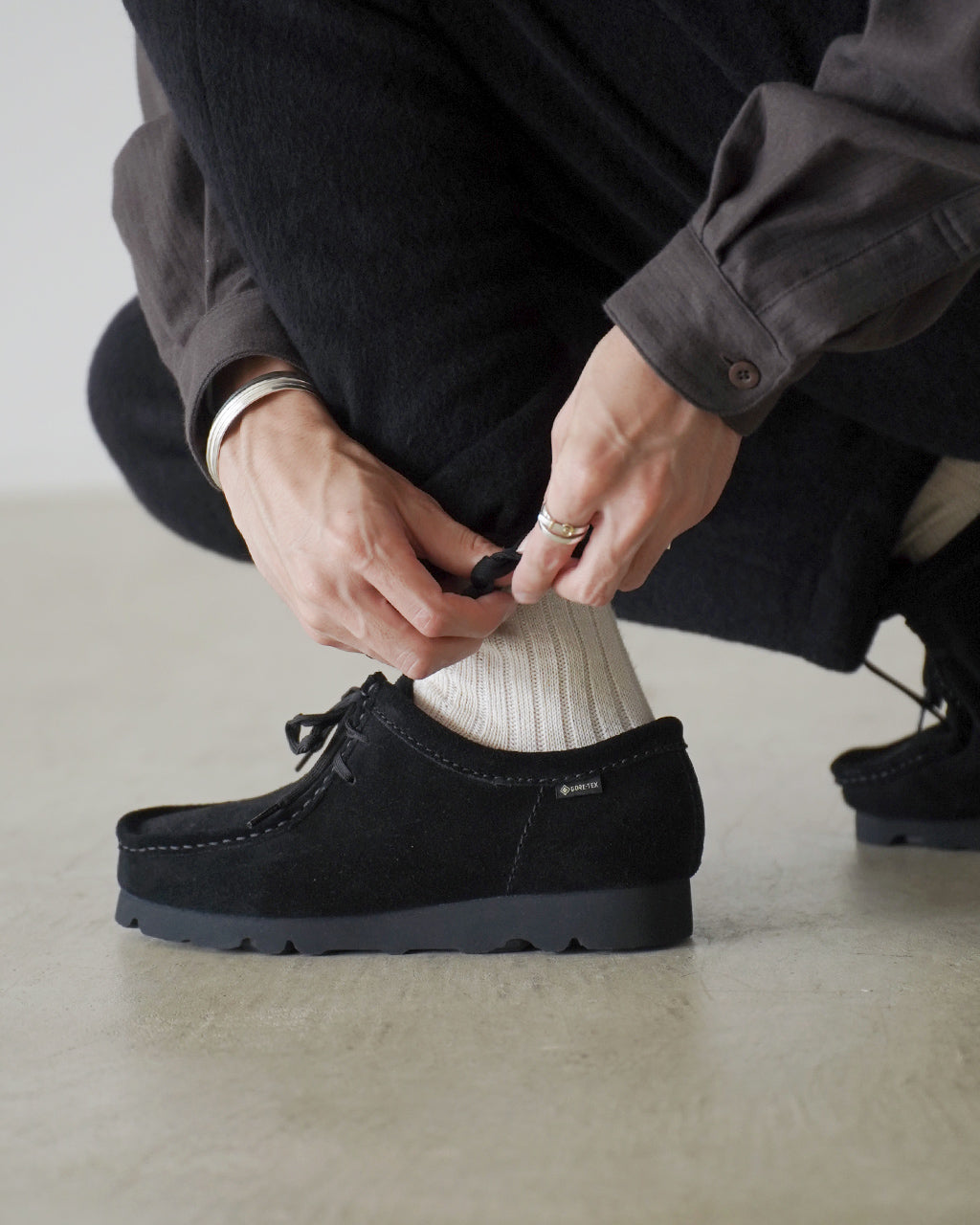 ブラックのSilk Wool Fleece Pants KS26FCS02を着用モデルが足元を撮影。裾へ向かって緩やかに細くなるリラックスシルエットと、ソフトな起毛素材の質感が見える写真