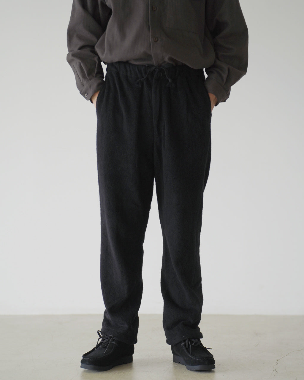 ブラックのSilk Wool Fleece Pantsを着用して腰まわりはゆとり、裾はやや細くスッキリ見えるパンツの前後胴部と脚部の全体像。
