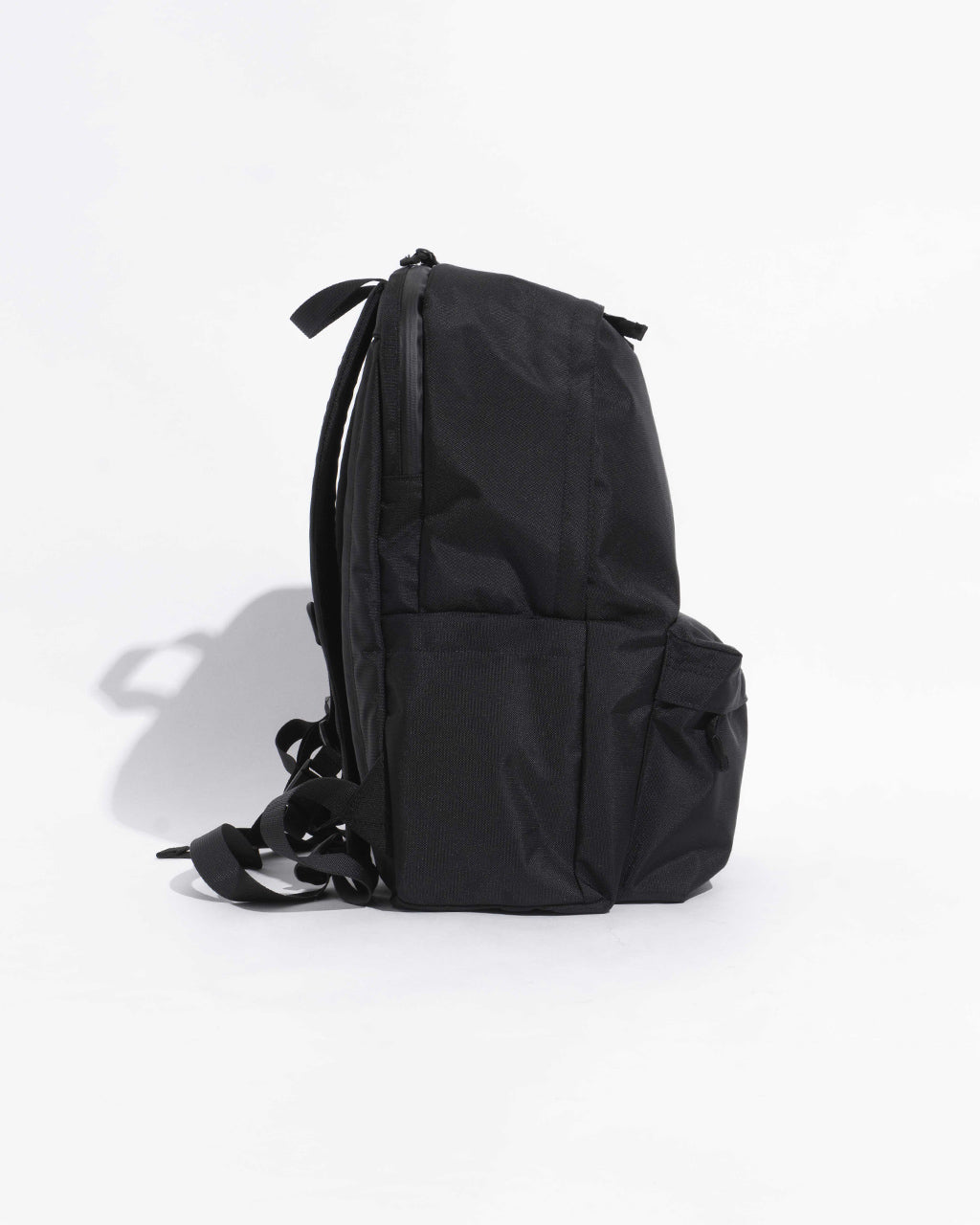 シンプルな黒のバックパック。側面から見たすっきりとしたシルエットと幾つかのポケットが目立つデザインです。