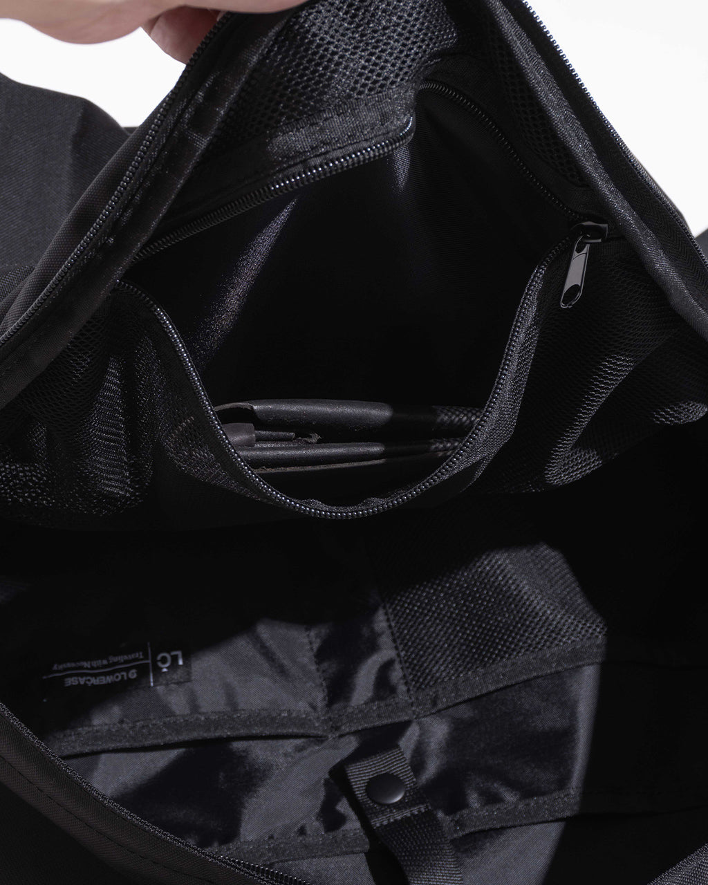 DAYPACK Lsizeの内部を開いた状態。メインファブリックの質感やジップポケット、PCスリーブ付近の構造が見える。黒系の内部収納が確認できるデザインショット。