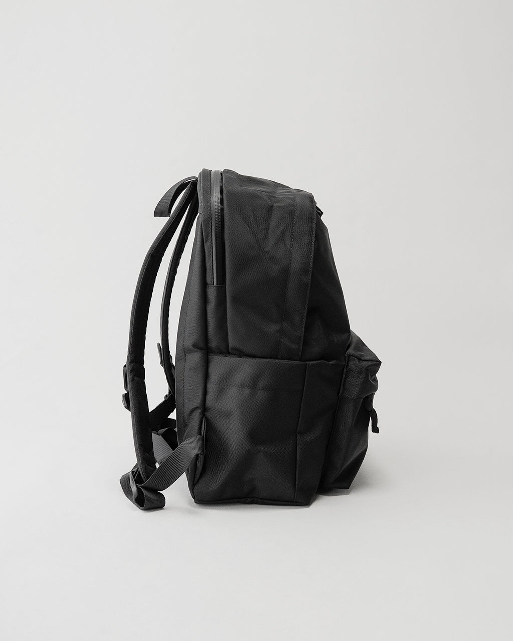 LC DAYPACK STANDARD 16Lの側面写真。黒のバックパックで、ショルダーハーネスとサイドポケットが見える。