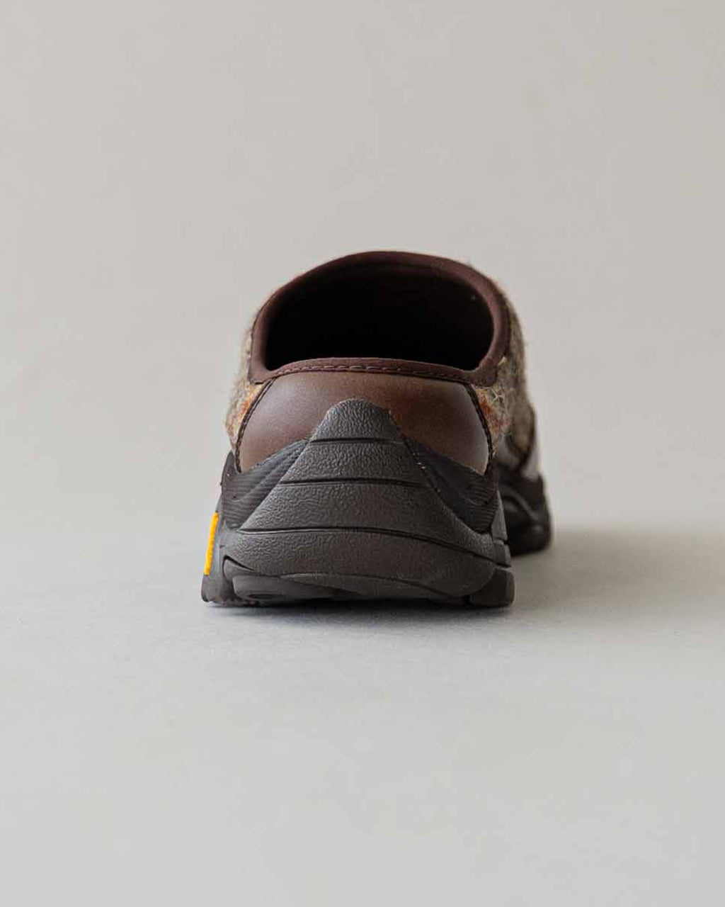 バックショットの MOAB 2 SLIDE X HARRIS TWEED。ダークウォルナット色のアッパーとアウトソールの組み合わせで、つま先からヒールへと滑らかなラインが特徴のスライドシューズ
