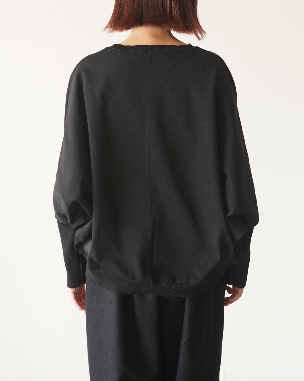 mizuiro indの cocoon POのバックショット。ゆったりしたビッグシルエットとドロップショルダー、裾と袖口のリブが見える黒のニットトップスです