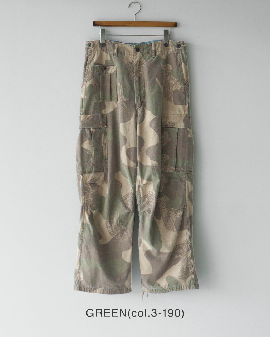 迷彩柄のARMY CARGO PANTの前面スタイル。ベージュ系とグリーンのカラー分布が特徴で、ウエスト周りとポケットのディテールが際立つパンツ。