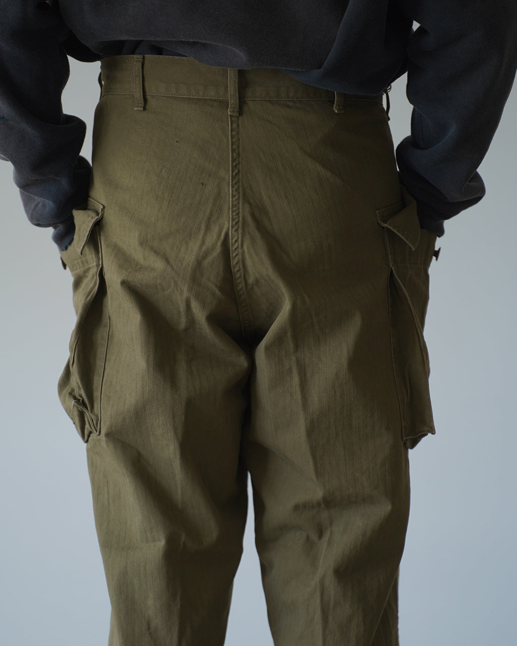 オアスロウのU.S ARMY 2 POCKET CARGO、カーゴポケットが両サイドに配された olive系カーキのパンツ。腰回りと背面の認識できるディテール、丈感が見える縦長ショット。