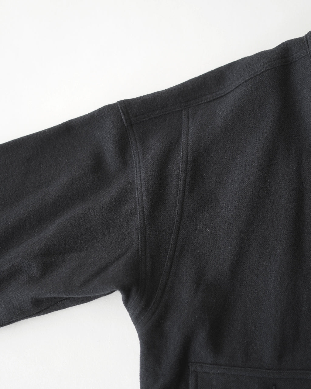 黒のウール素材で作られたOUTIL VESTE ABOS OV-T055の肩周り。縫い目のディテールと袖口のラインが露出しており、硬めの生地感が伝わる前面ショット。