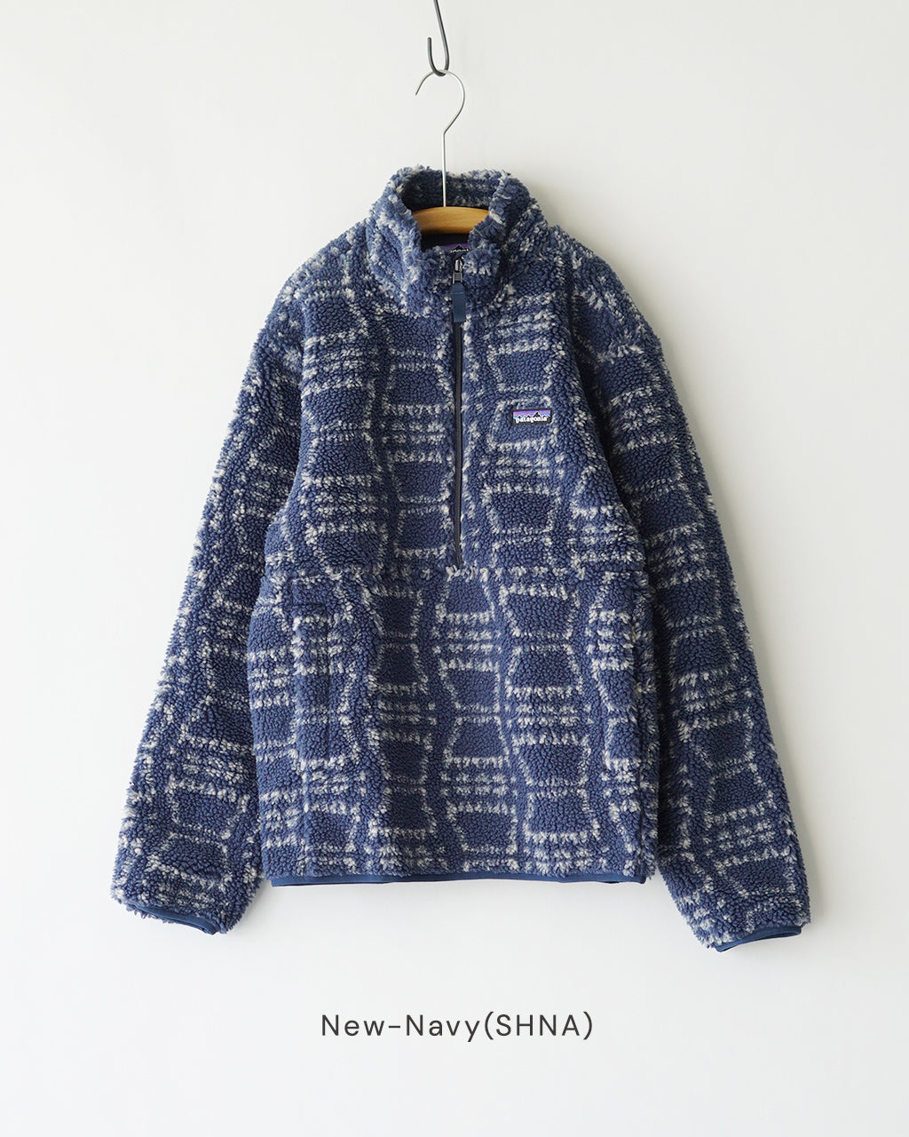 新 Navy のボアジャケット、ハーフジップ付きの着丈ミディアム丈で、模様は格子状のブロックパターン。胸元に小さな Patagonia ロゴラベルが配置されている