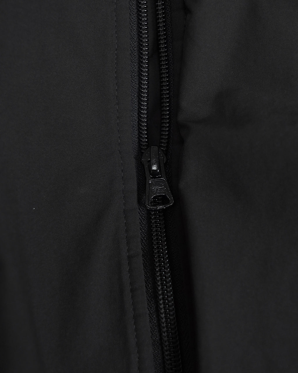 黒色の Weather Flight Jacket のジップアップ部分。ファスナーと縫製がクローズアップされ、素材の滑らかな表面感が伝わるディテールショット