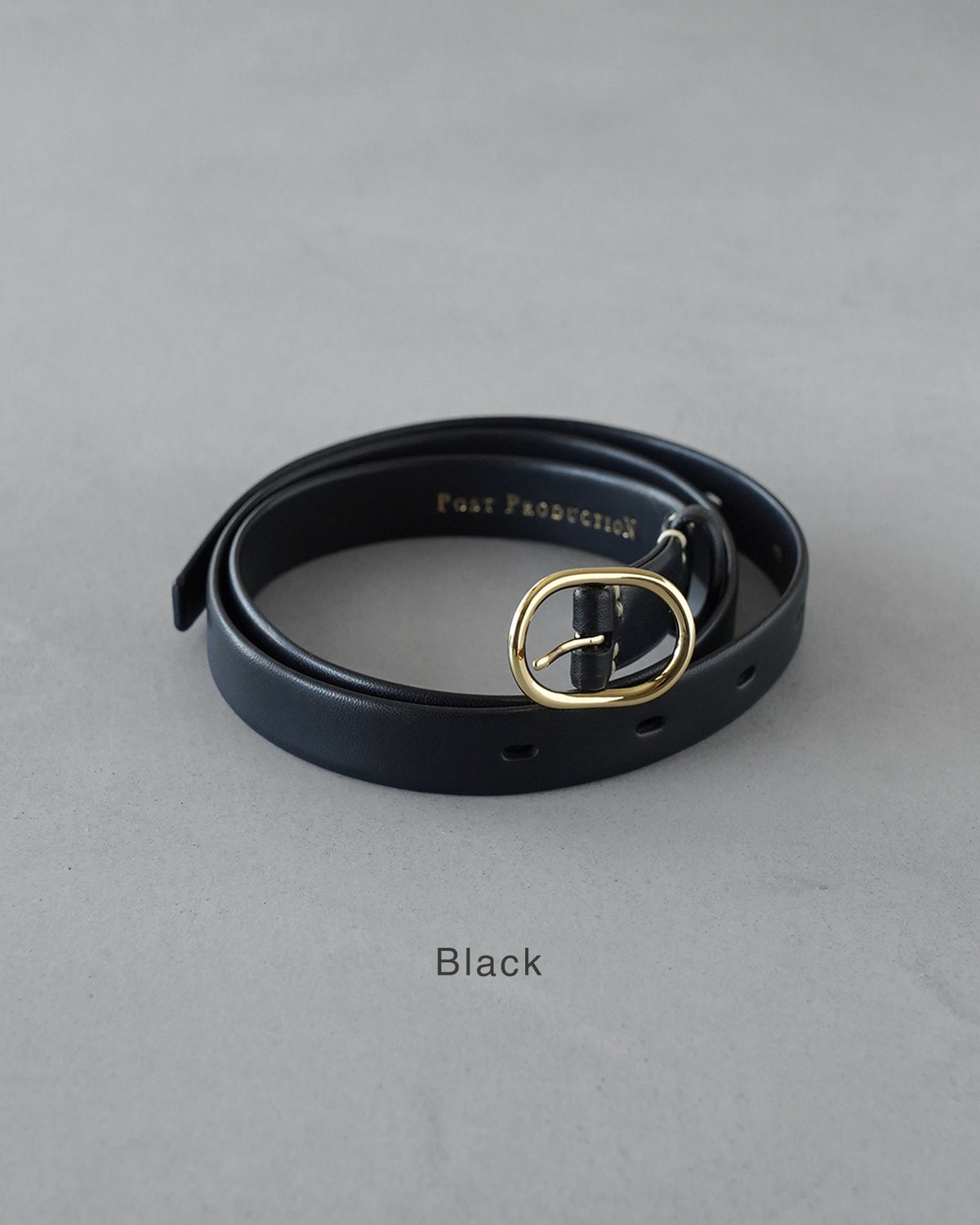 黒い革ベルトの正面ショット。金色のバックルが中央に際立ち、 horse-waxで仕上げられた風合いが伝わるアップ画像