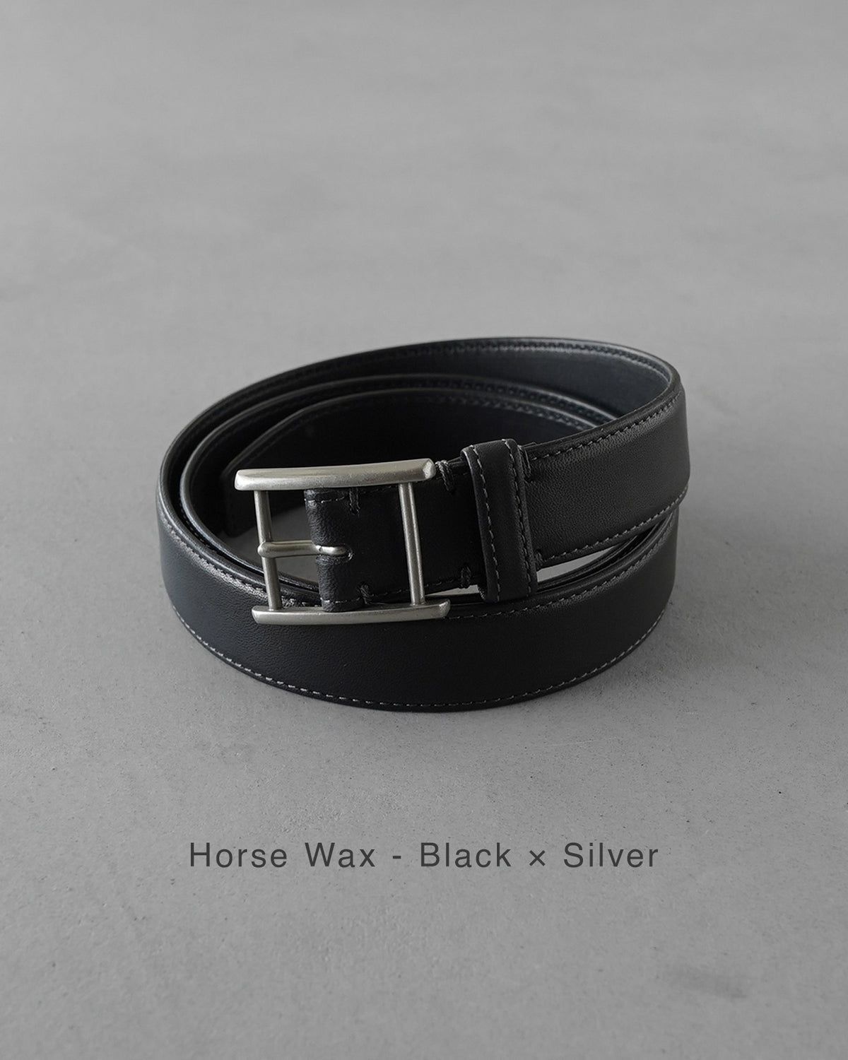 ブラック×シルバーのHorse Wax仕様のベルト。幅は28mmで、バックルはオリジナルの細身デザイン、革身が厚めで艶やかなCalf素材が特徴。