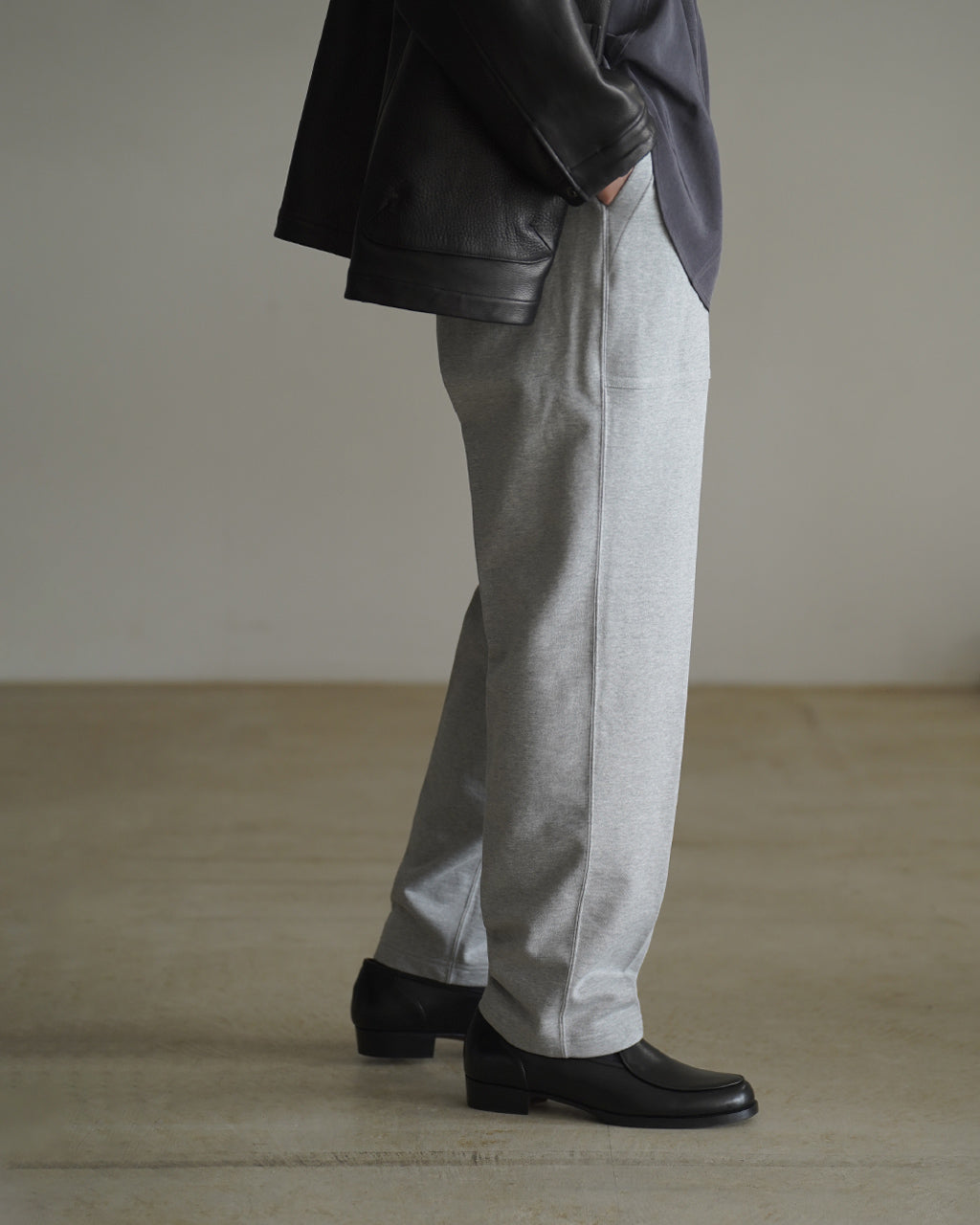 グレーの裏毛スウェットパンツ、腰まわりにゆとりを持たせ裾に向かってテーパードするシルエット。ポケットが特徴的で、シックなパンツスタイルを演出します。