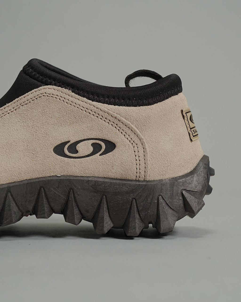 サロモンSNOWCLOG OGの横からのアップ。ベージュ系のアッパーと黒い縁取り、凹凸のあるアウトソールの特徴が見える横顔です。