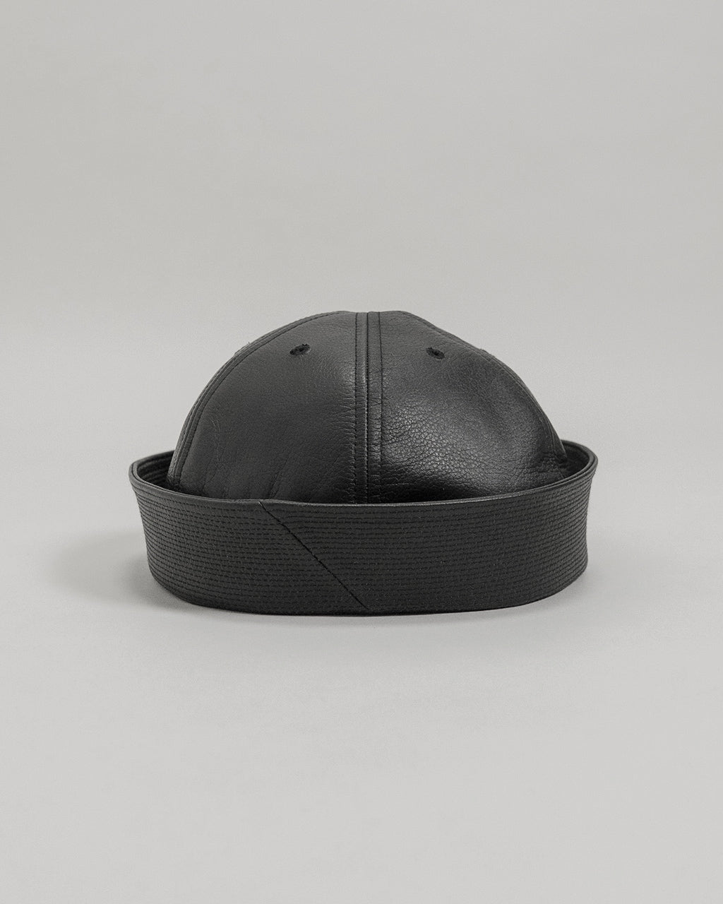 SOLARIS&CO.のCOWHIDE SAILOR HAT / SHEPHERDの黒系レザー帽子。丸みを帯びたクラシックなデザインで、つやのある質感と太めのブリムが特徴的。