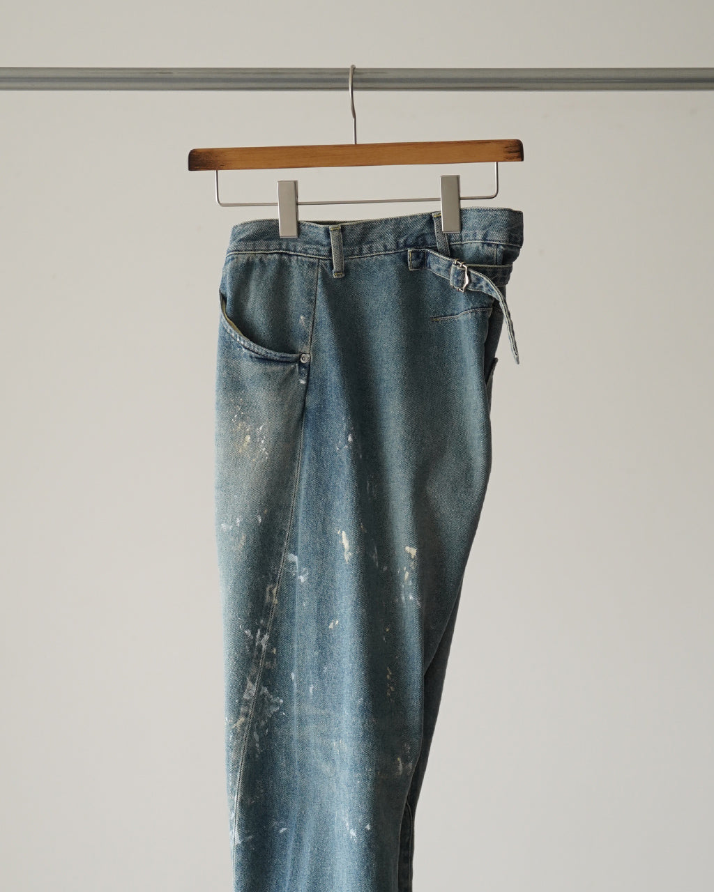 背面にバックシンチが見える、淡いブルーのデニムパンツ。サイドからはきれいな落ち感とクラシックなポケットの形状が確認できる