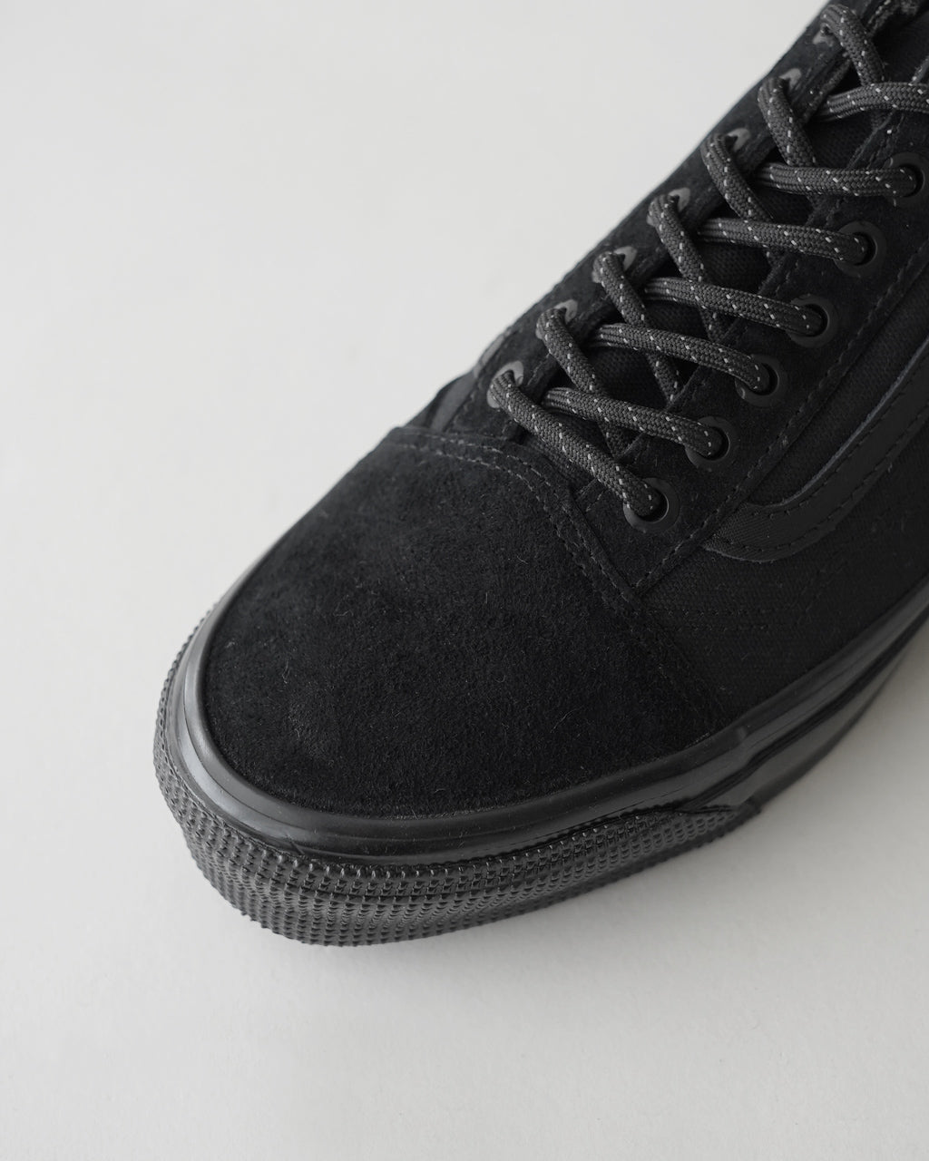 VANS LX Old Skool GTX ブラック系のアッパーアップ画像。レザーとテキスタイルを組み合わせた黒色の靴紐が目を引くローカットのスニーカーの正面アップ。