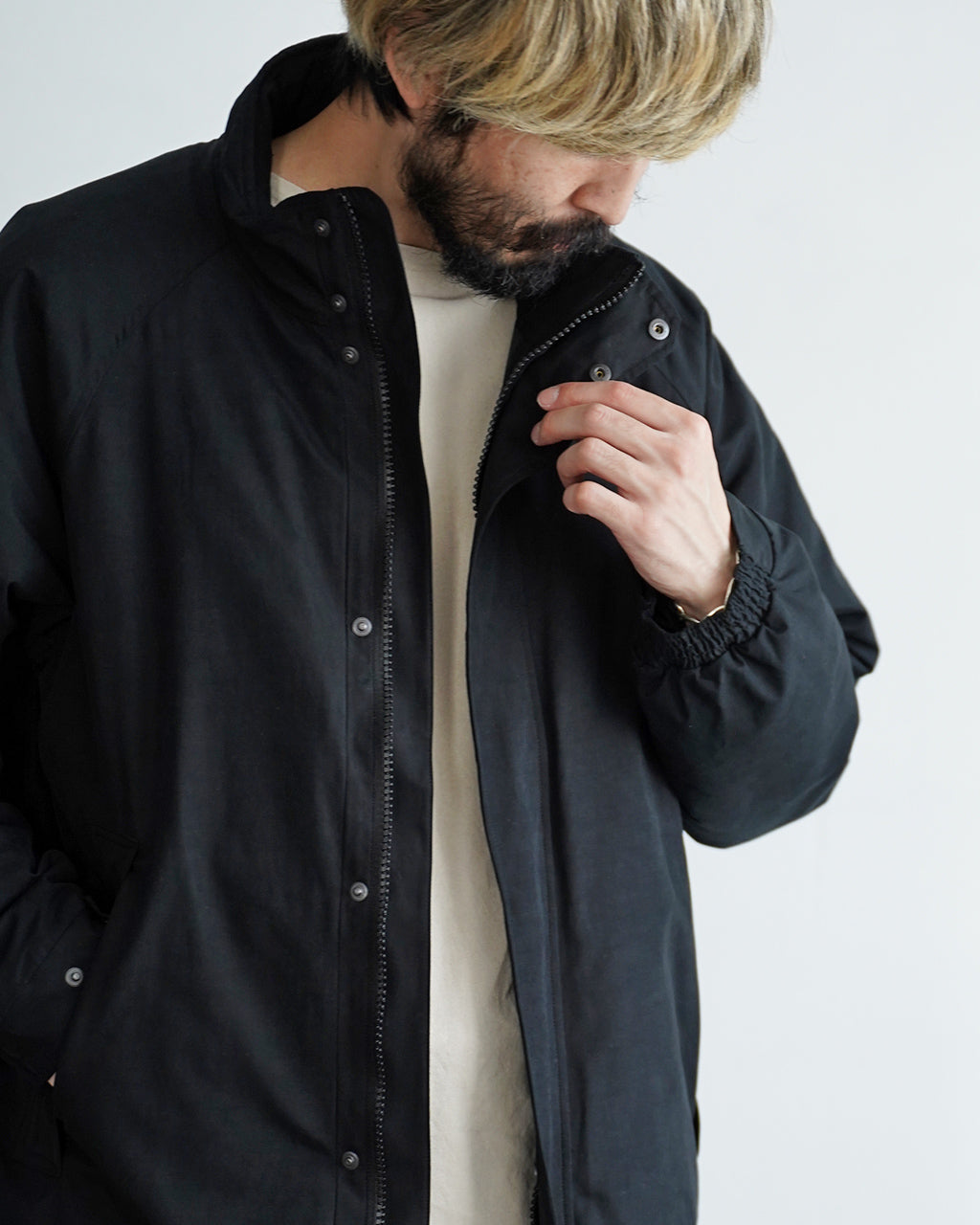 A VONTADE Baggies Jacket Ver.2 の前開きデザイン。黒系の軽量ジャケットで、ジッパーとボタンの比翼仕立てが特徴的。襟元と袖口は絞りデザイン、袖口を外した堅実な雰囲気がうかがえるDETAILショット。