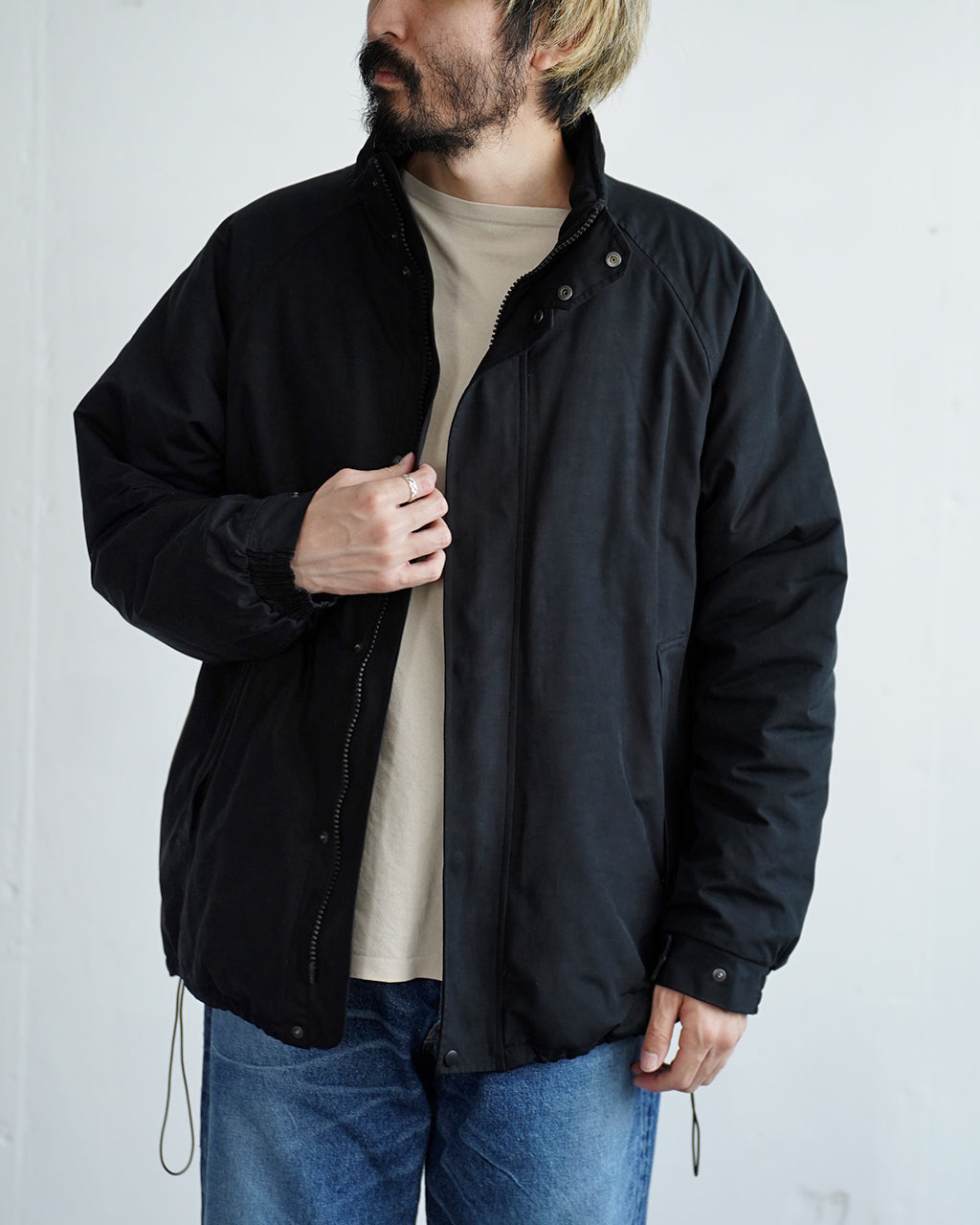 ブラックのボリューム感あるBaggies Jacket Ver.2の正面。ジッパーとスナップで開閉する比翼仕立ての前立てと高密度な表地が見える。