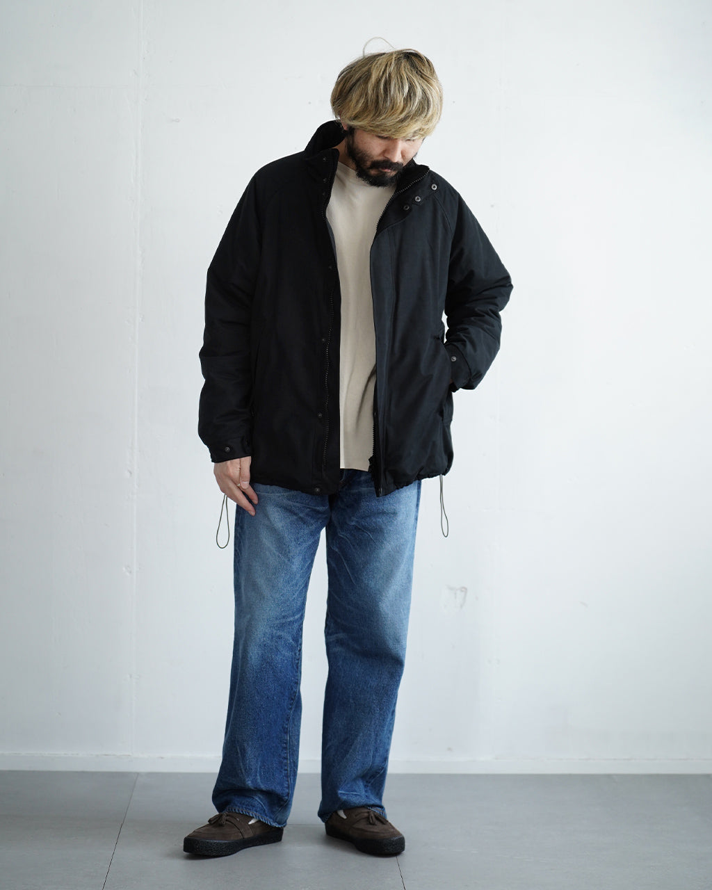 ブラックのBaggies Jacket Ver.2を着用した男性モデルの全身ショット。ジーンズとベージュのインナーでカジュアルな印象。