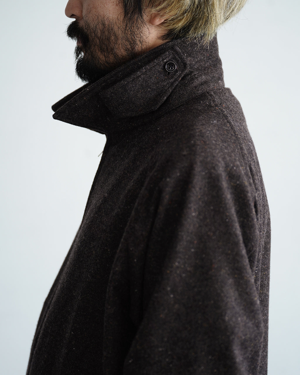 襟元をアップで捉えた黒系の Harrington ジャケット。厚みのある素材感とボタン留めのスタンドカラーが特徴的なディテール画像です。