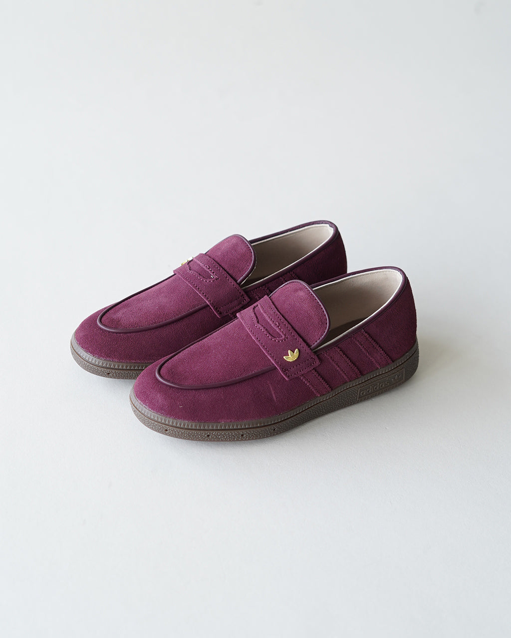 アディダス オリジナルス HANDBALL SPEZIAL LOAFER のワインレッド系スエードローファー、ブラウンソールとゴールドのロゴがアクセントのシンプルな佇まい