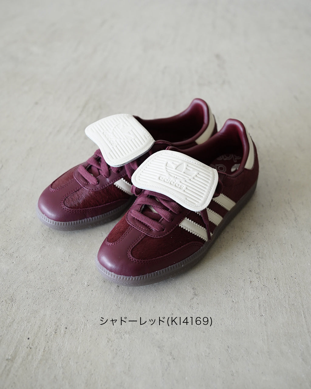 シャドーレッドのアディダス サンバLT KI4169。ボルドー系のレザーと白の三本ラインが際立ち、白いベルト状のロゴパーツが特徴的に見える。