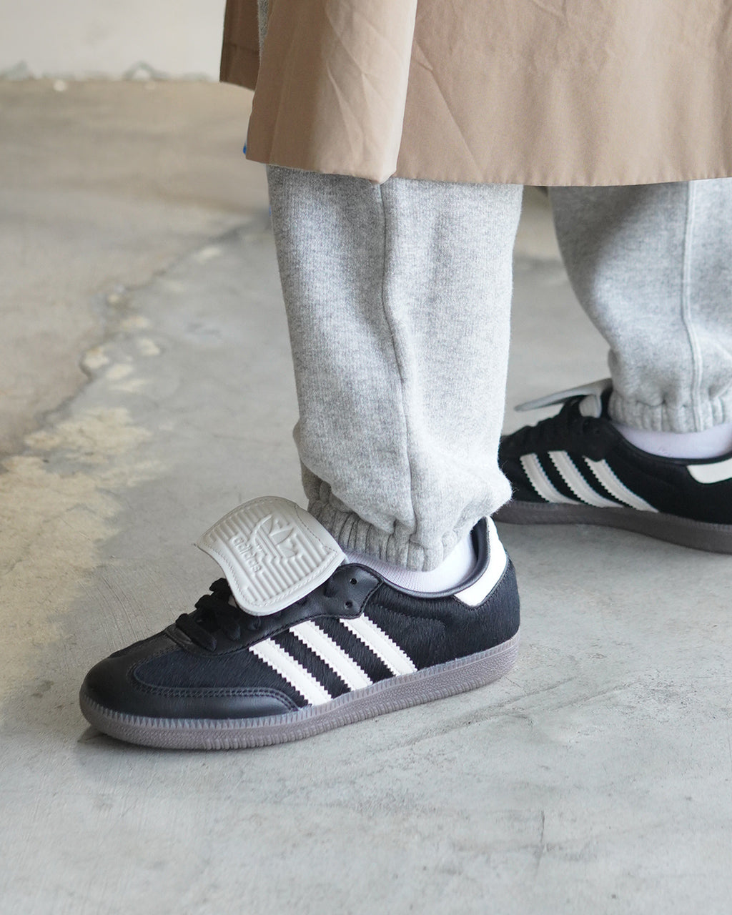 adidas originals SAMBA LT の黒系スニーカー。白の三本ラインと黒のアッパー、グレーのアウトソール、かかととシューレース周りの細部が目を引くデザイン。着用イメージの着地感とボリューム感を伝えます。