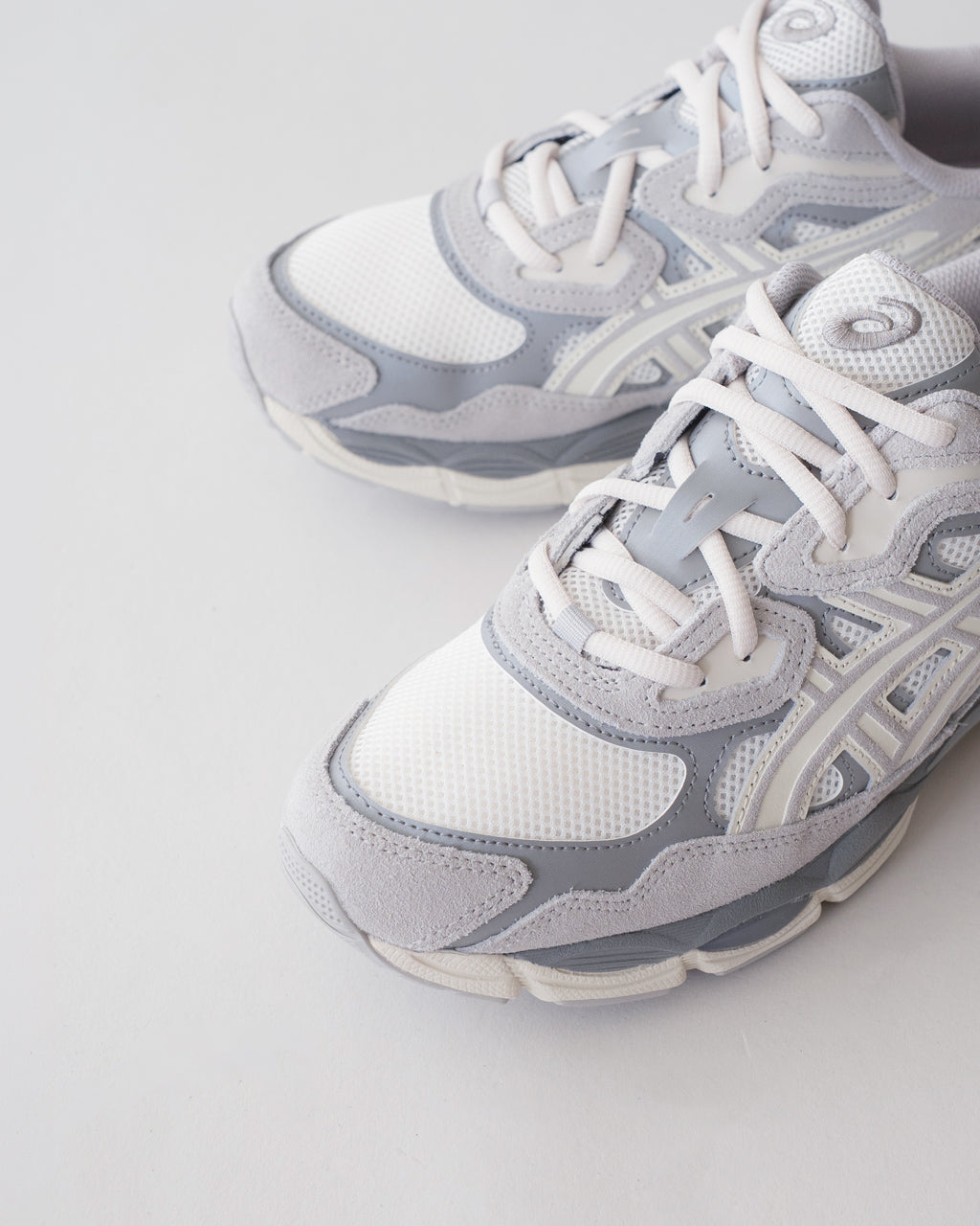 グレーと白の配色が特徴のASICS GEL-NYC 1201A789の詳細。前方から見た安定感のある形状とメッシュ素材の質感が確認できるショット。