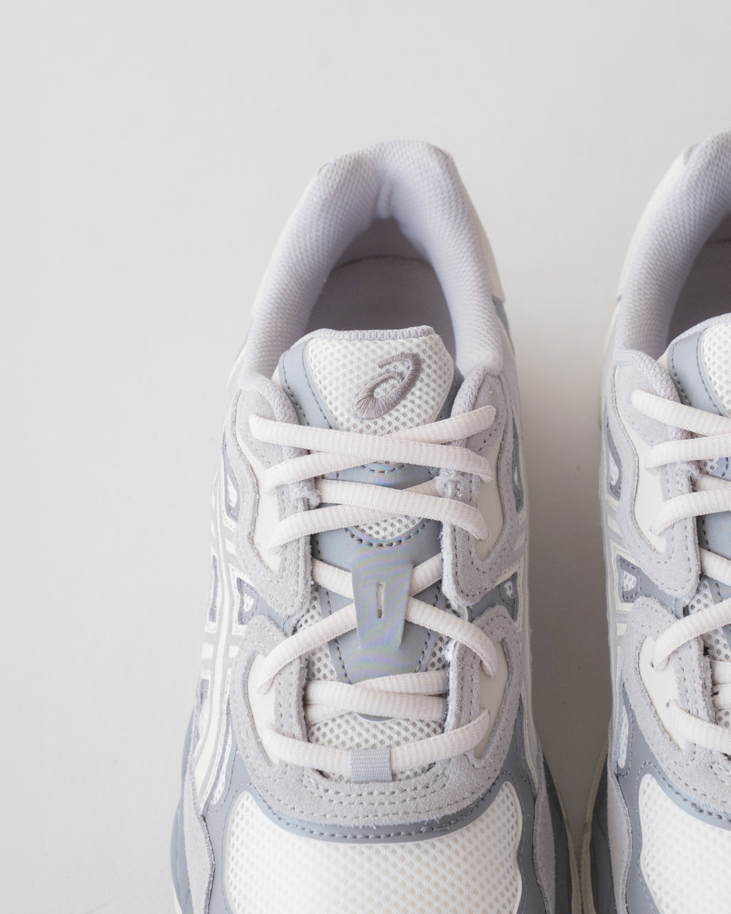 ASICS GEL-NYC の前面アップ。白と淡いグレーのメッシュとレイヤー構造が見て取れるスニーカーのつま先周りと紐のディテール