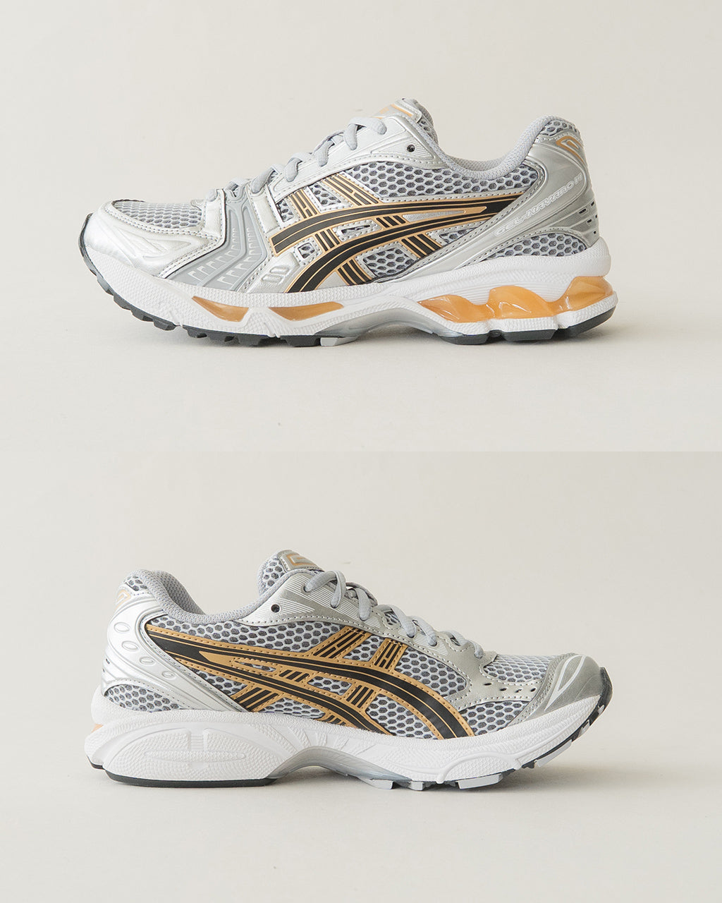ASICSスポーツスタイルのGEL-KAYANO 14を横から見たシルバーメッシュとグレーのアッパー。ゴールドとブラックのアクセントが特徴的なデザインで、厚みのあるソールが目を引く写真です。