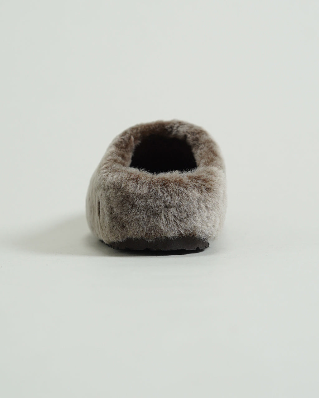 BIRKENSTOCK Amsterdam Wrapped Shearlingのアップショット。ふっくらとしたシアリングが足元を包み込み、柔らかなベージュ系の毛並みが際立つ前方ショット。