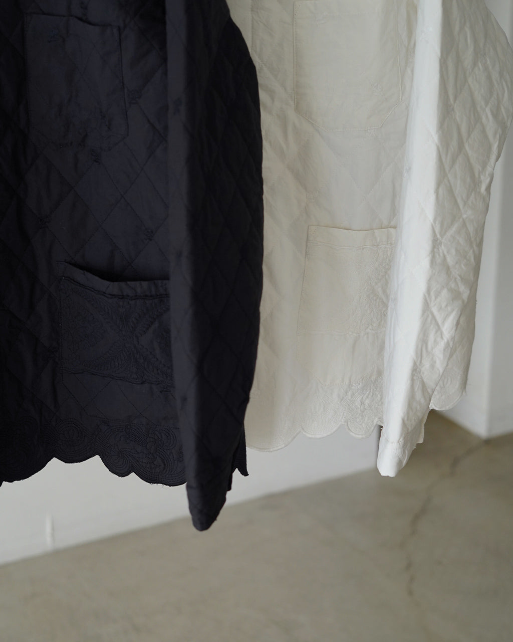 刺繍が際立つボーダー風パッチワークのジャケット。黒と白の対照的な色合いで、裾にレース風のスカラップディテールが見える前後の比較がわかる一枚。