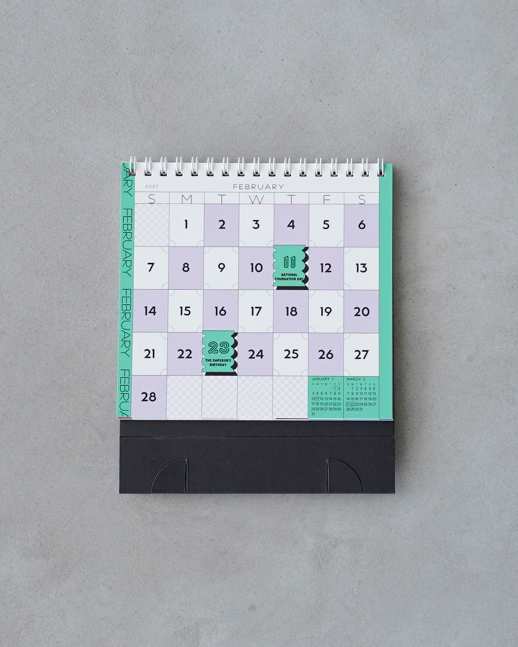 卓上チェス盤をモチーフにした Chess Desk Calendar の正面全体像。薄い紫と緑の配色で日付欄が並ぶデザインと、下部の黒いスタンドが見える写真。