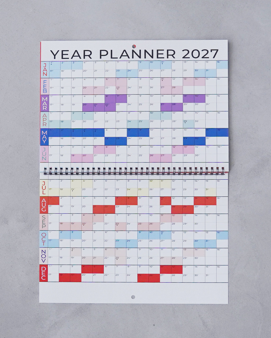 見開きA3サイズの波模様カレンダー。表紙には YEAR PLANNER 2027、色とりどりの月間グリッドとリング綴じが特徴的な壁掛け用デザインです。