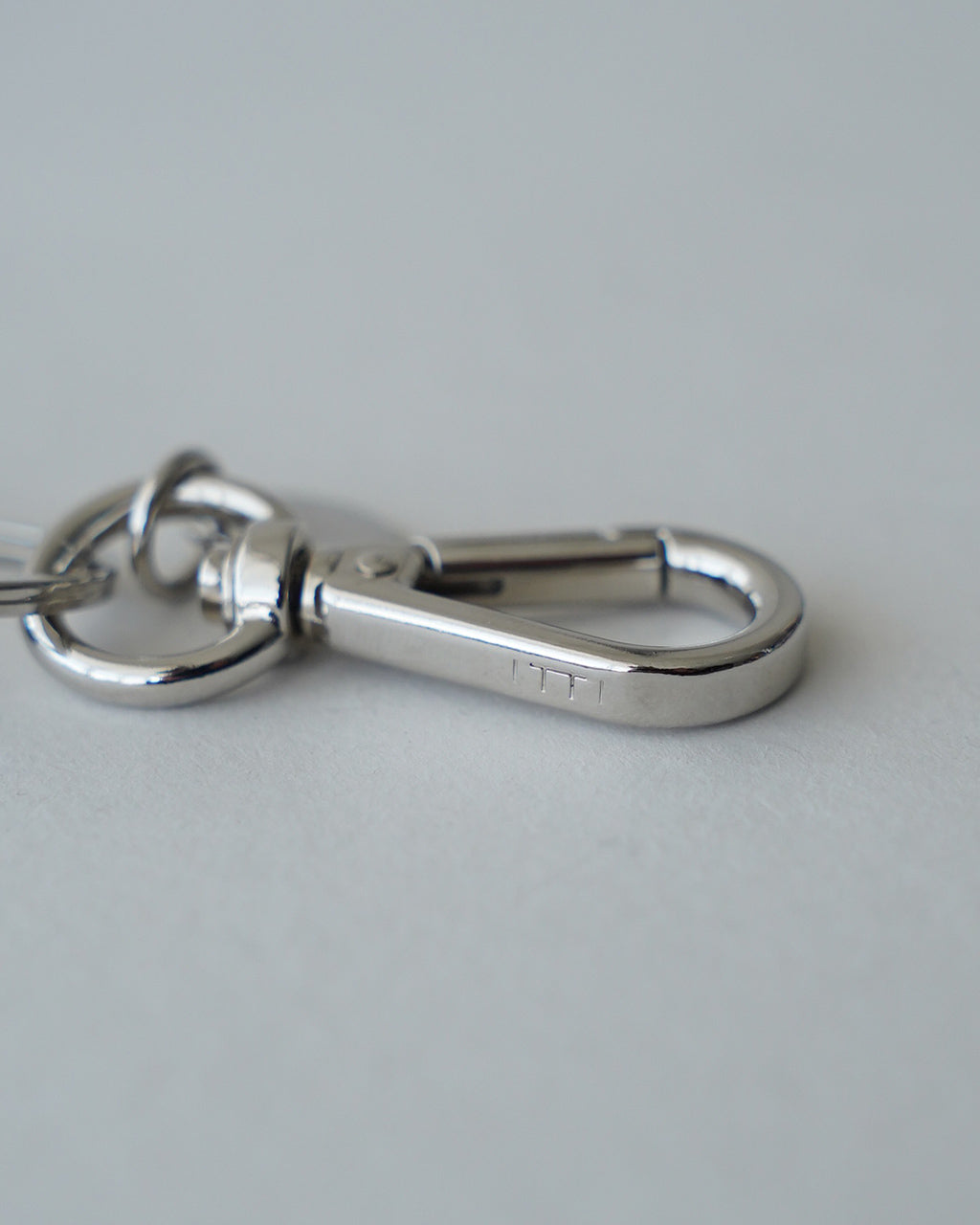 ITTI イッチ CRISTY SNAKEKNOT CHARM の金具アップ。シルバーのリングとカラビナ風パーツが際立つ、手作業で編み込まれたレザーロープのディテールが映えるクローズアップ