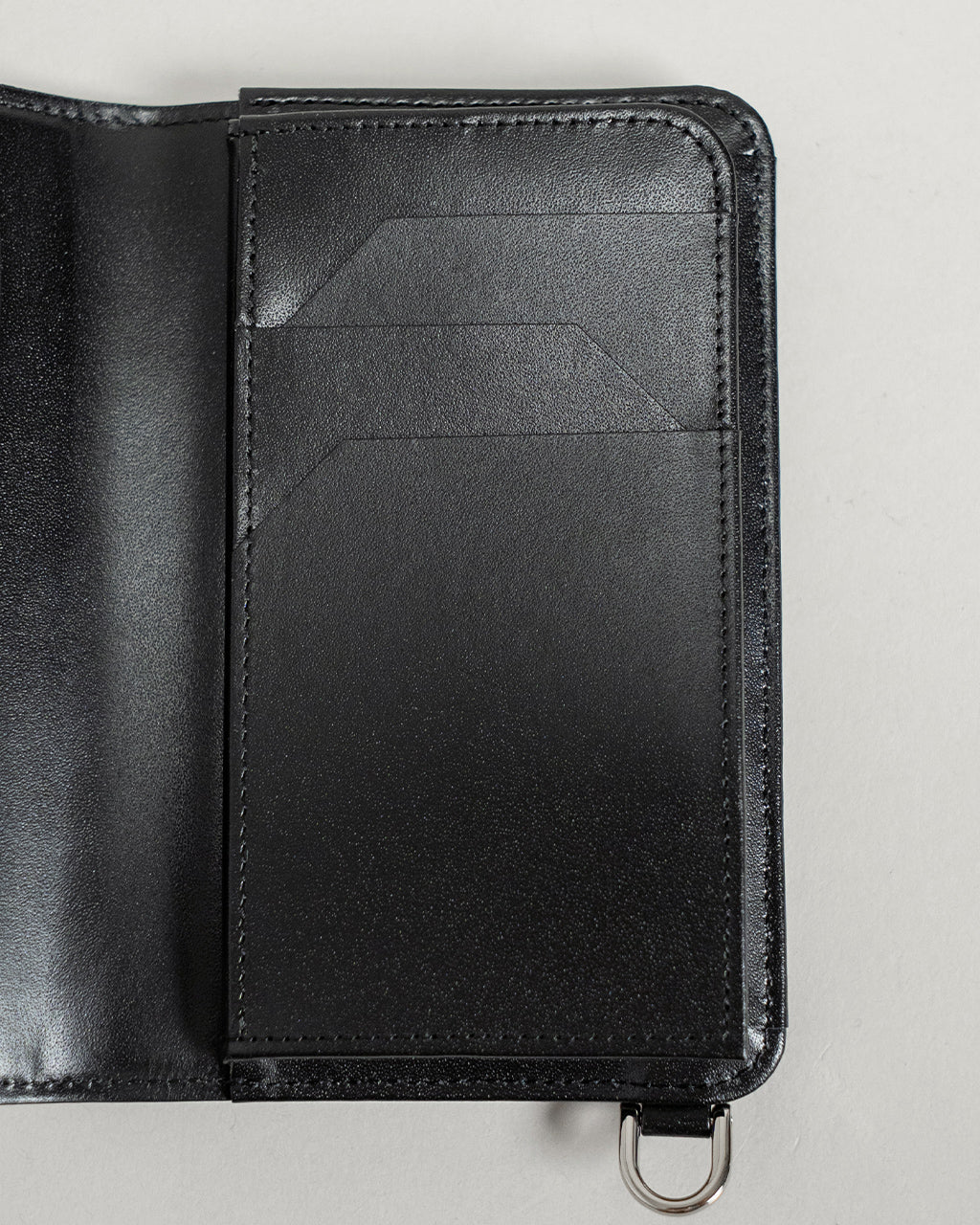 CRISTY WIND SMART MID WLT CROCOのブラックカラー、カードポケットが前面に見えるジャストサイズのミニウォレット。クロコダイル型押しの表情と艶やかな革質が特徴的なディテール画像