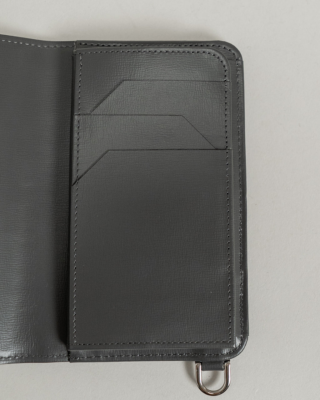 ITTIのRAPTO PREMIERシリーズのブラック系財布。開いた左側ポケットと、右側のカードポケット群が見える、上質なレザーと立体的な縫製が際立つディテールが特徴です。