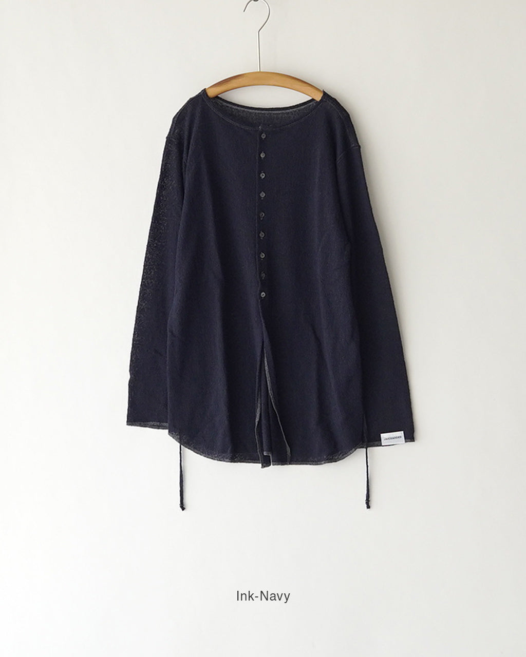 前長めの丈感の、インクネイビーのカーディガン。前後どちらも着用可能な2WAY仕様で、裾には紐とドローストリングが見えるデザインです。