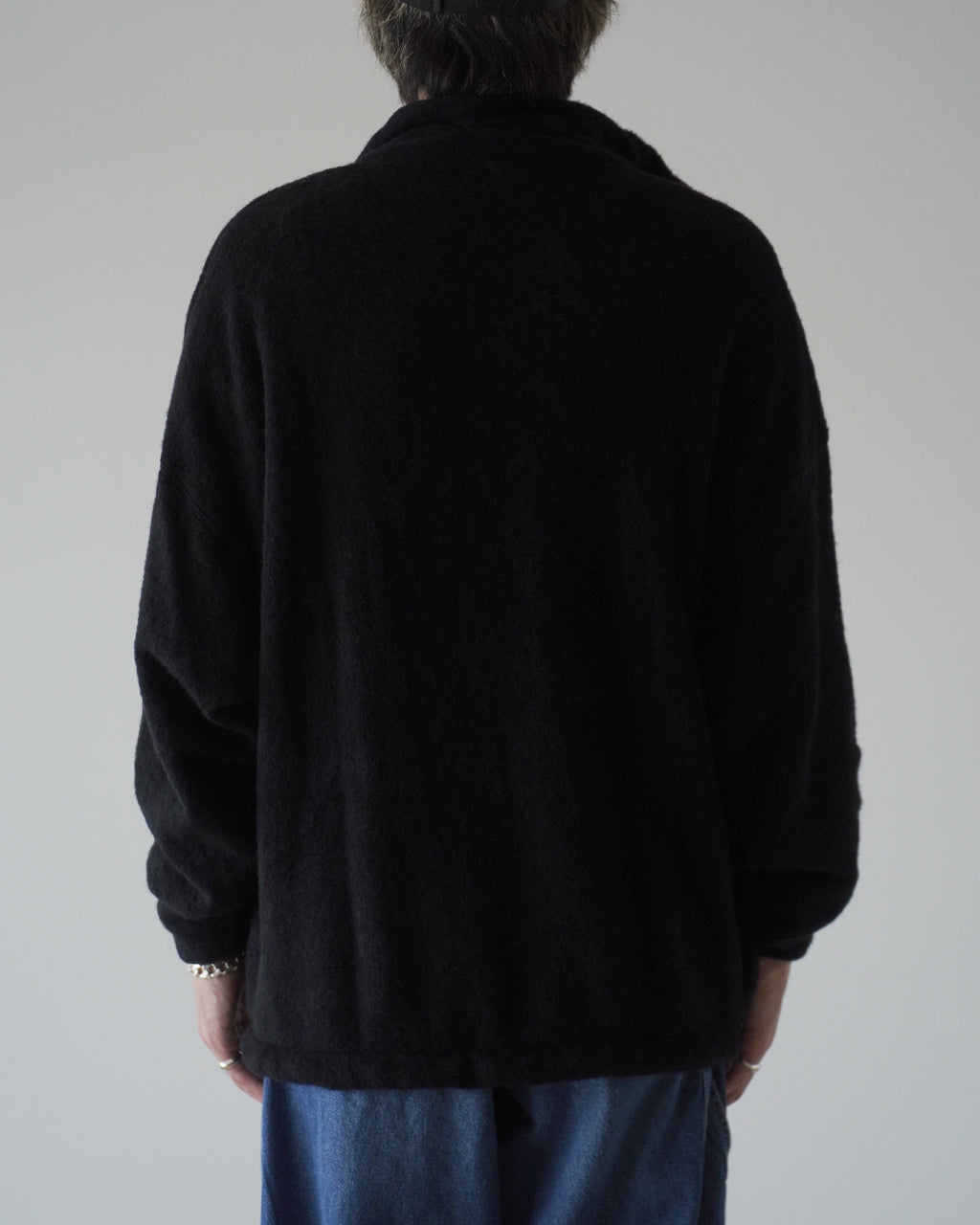 後方から撮影されたブラックの Silk Wool Fleece Pullover。立体感のあるふくらみと肩周りのゆったり感が見て取れるシルエット。