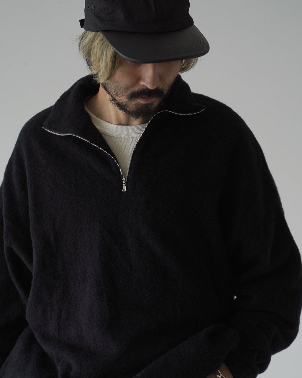 黒の半袖ハイネック風ではなく、スタンドカラーと半ジップのフリース pullover のアップ