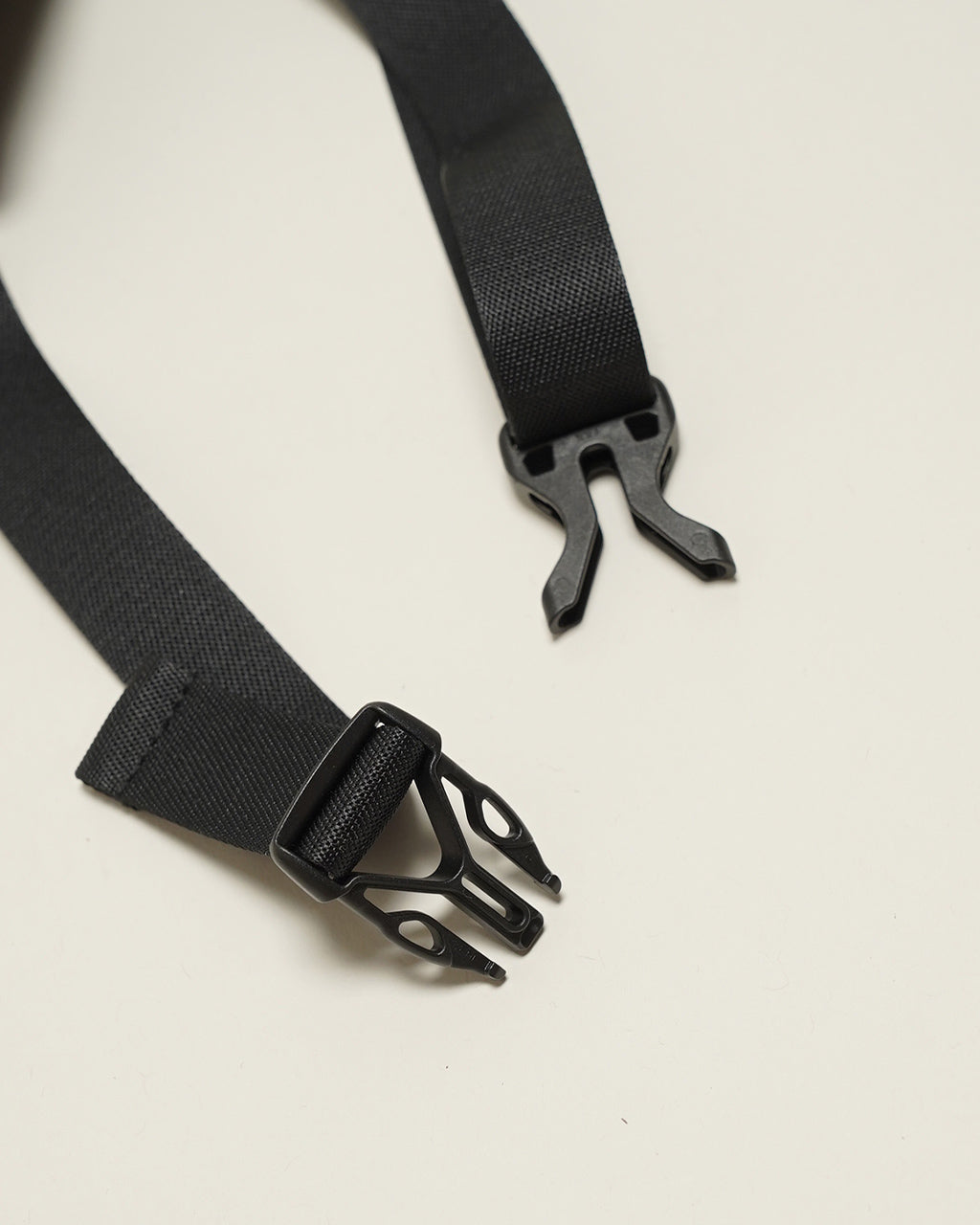 KARRI AMIACALVAの WAIST BAG K011のバックルとストラップの一部。黒色のナイロン素材と細部のパーツを特写。