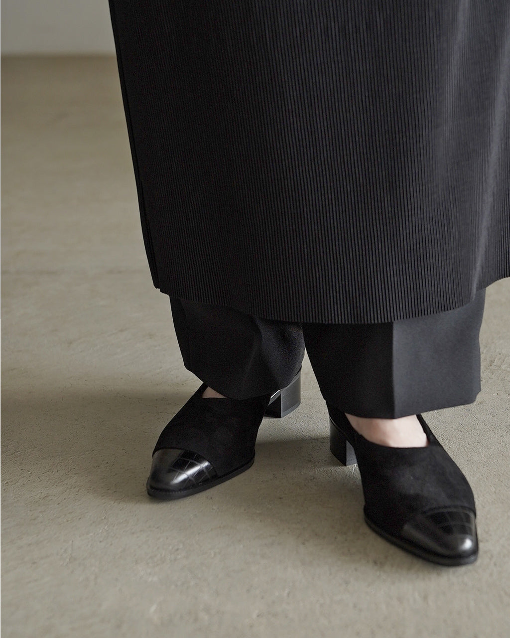 KATIMのパンプス、黒のレザーとスエード風素材の組み合わせで、つま先はシャープなポインテッドトウ。ヒールは約4cm、高さがありながら日常使いもしやすいデザインです。