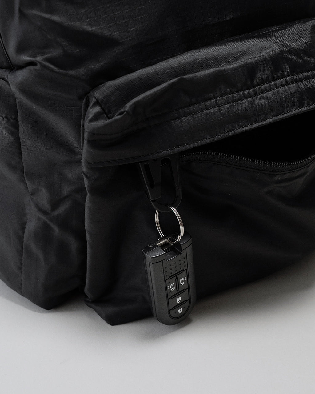 ブラックのLC DAYPACK LITE 20Lのファスナー部分とカードキーケースの近接。丈夫なナイロン地と折り返し縫製が見える写真
