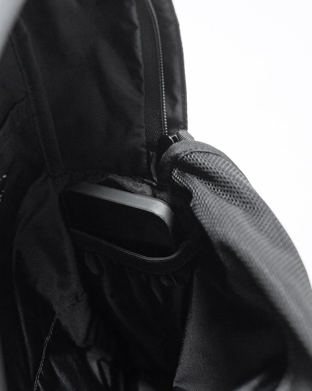 LC by LOWERCASEの DAYPACK LITE 20Lの内部ポケット周辺を捉えた黒色のバックパック。ジッパー付近と内部スリーブのディテールが見える。