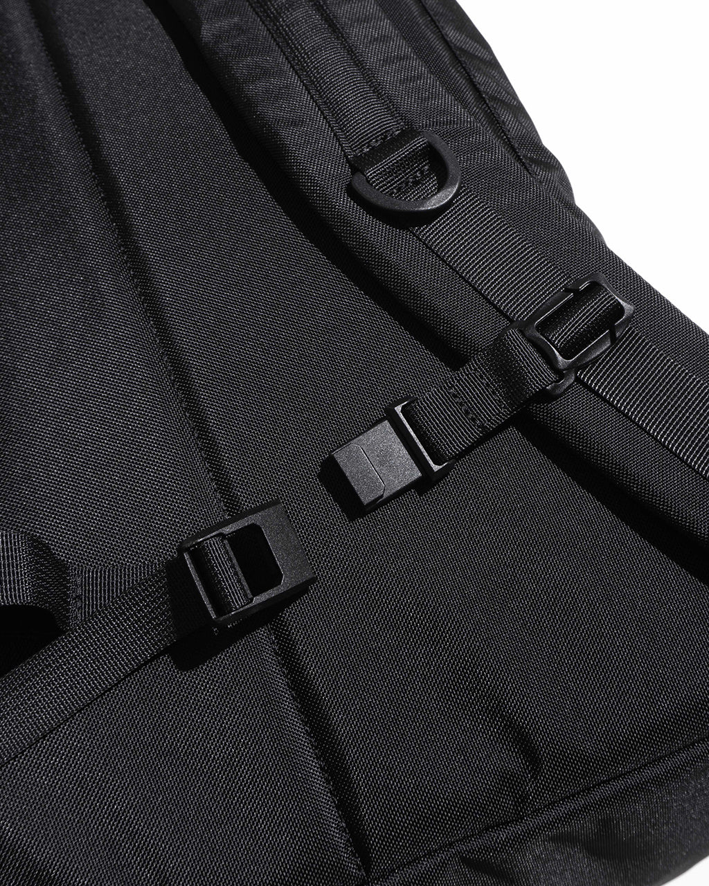 ブラックの DAYPACK Msize の背面とストラップ周り。金属バックルとDリング、ショルダーベルトの作りが見える細部ショット。